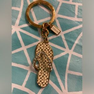NWOT Coach signature gold and white flip flop keychain.